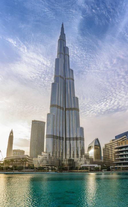 View of the Burj Khalifa in Dubai, United Arab Emirates, the world's tallest building, towering over surrounding skyscrapers and a turquoise water feature.